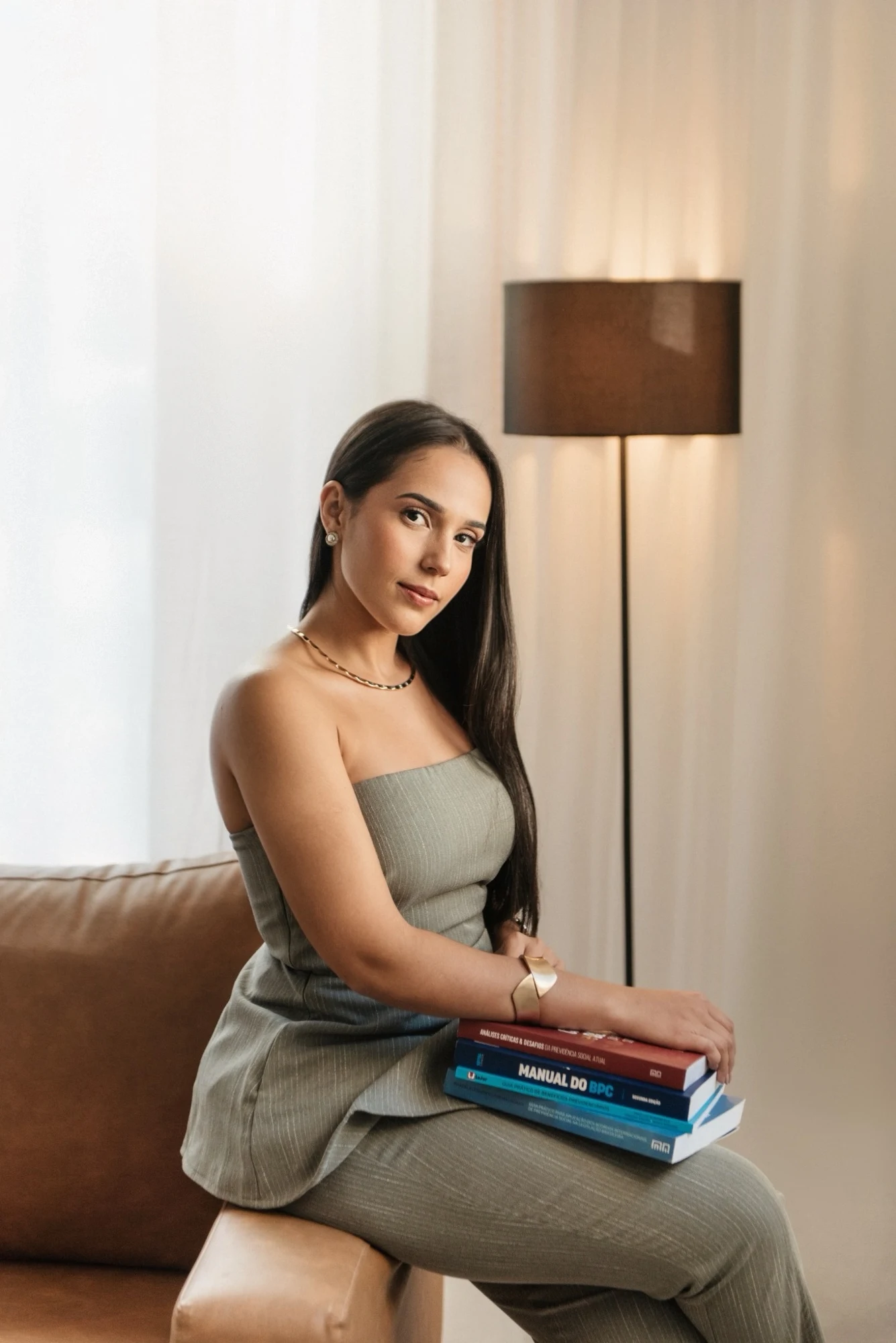Dra. Bruna Benichio sentada com livros de Direito